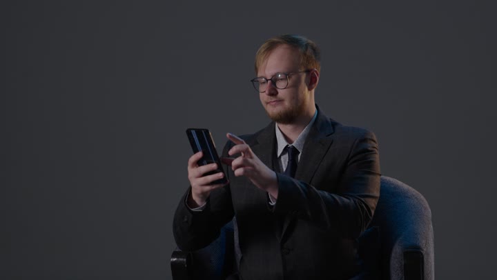 Businessman Using Smartphone in Dark Studio Lighting