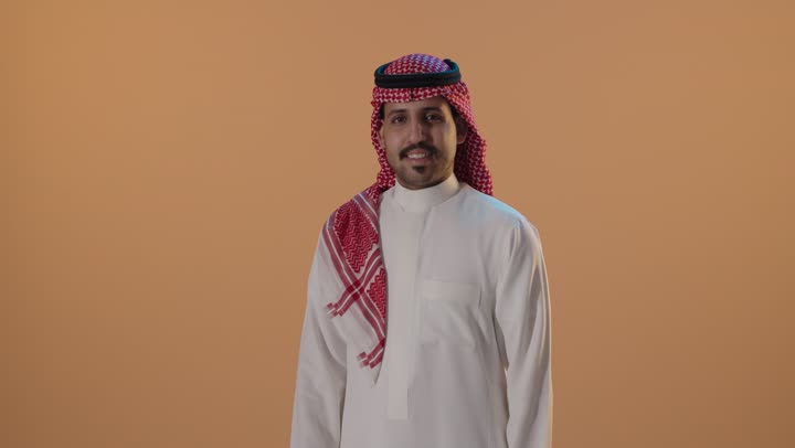 رجل سعودي يقوم بإيماءة الإبهام في الاستوديو