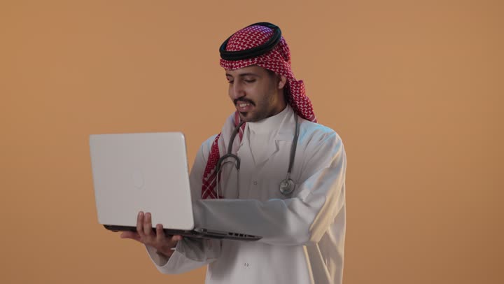 Saudi Male Doctor Using Laptop in Studio