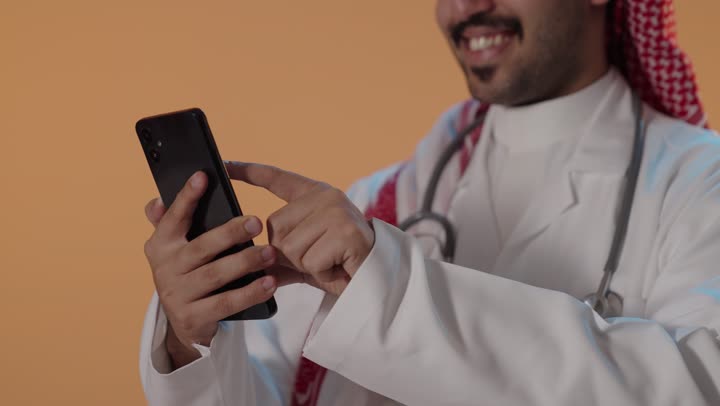Saudi Male Doctor Using Smartphone in Studio