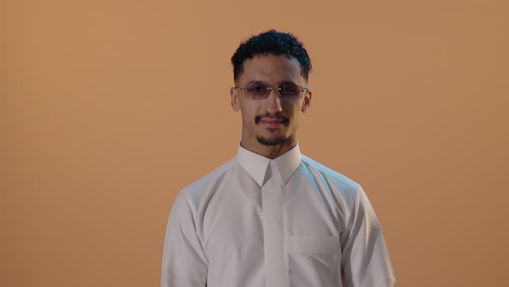رجل سعودي بالثوب يشير إلى ابتسامته فيديو استوديو