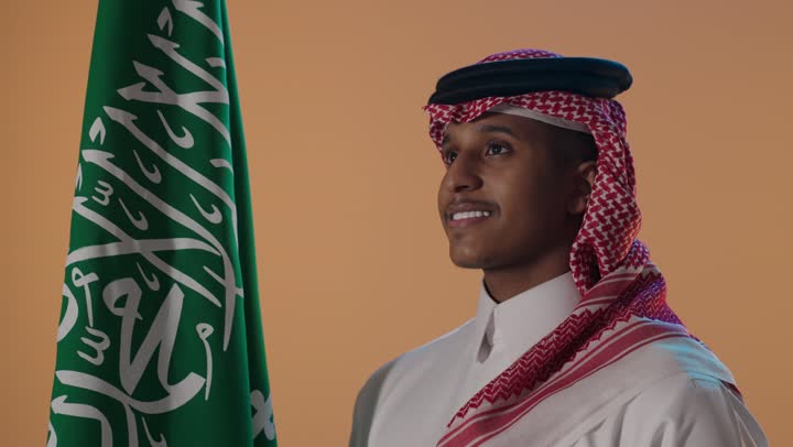 بورتريه لشاب سعودي مع العلم الوطني في استوديو