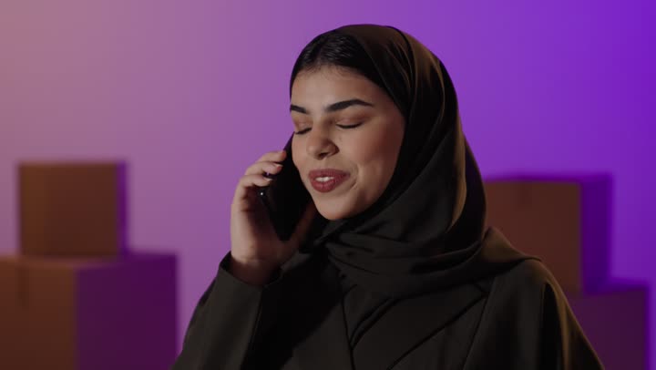 امرأة عربية تتحدث على الهاتف الذكي في الاستوديو