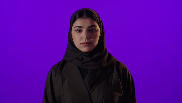 امرأة عربية بالحجاب حركة التوقف خلفية أرجوانية