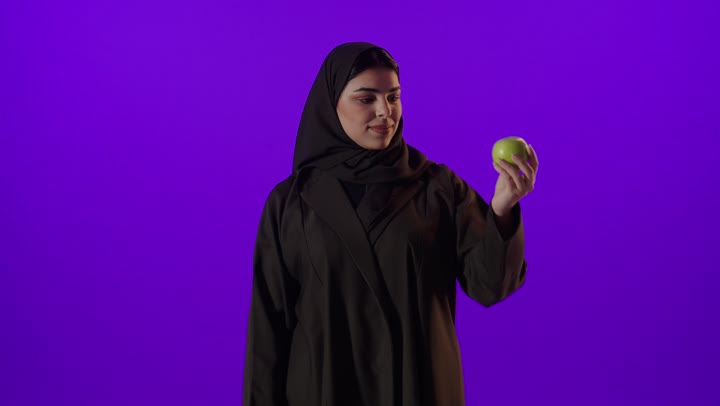 Saudi Woman with Green Apple Thumbs Up Studio Footage