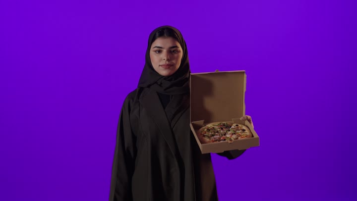 امرأة عربية تحمل علبة بيتزا علامة الإعجاب خلفية أرجوانية
