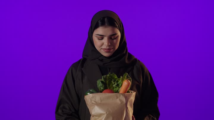 امرأة سعودية تحمل حقيبة خضروات طازجة في الاستوديو