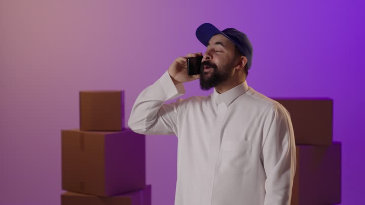 Saudi Male Courier Talking on Smartphone in Studio