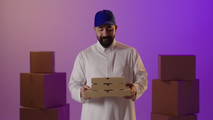 رجل توصيل سعودي يحمل صناديق بيتزا في استوديو