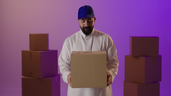 رجل سعودي يحمل صندوق شحن في استوديو