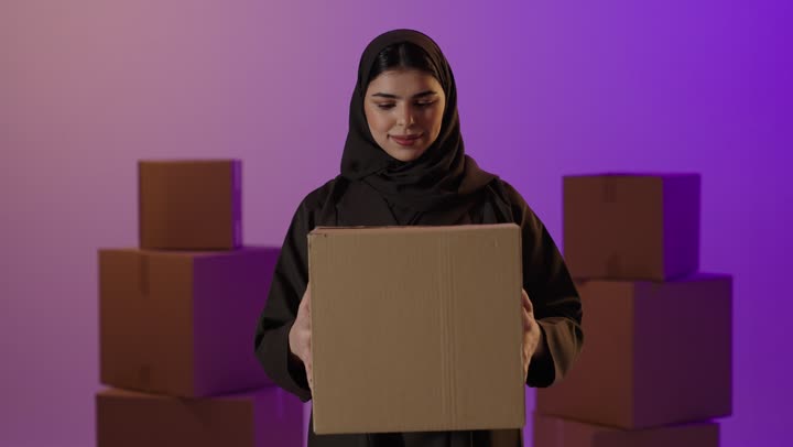 امرأة سعودية تحمل صندوق توصيل في الاستوديو