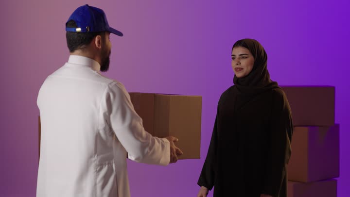 Saudi Delivery Man Handing Box to Arab Woman