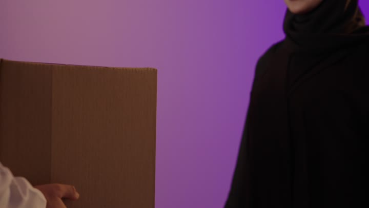 Arab Delivery Man Handing Package To Woman Studio