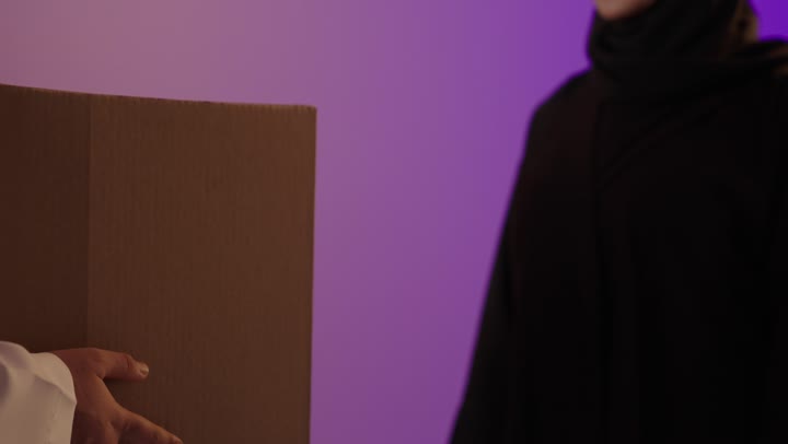 رجل عربي يسلم طرد لامرأة بالعباءة