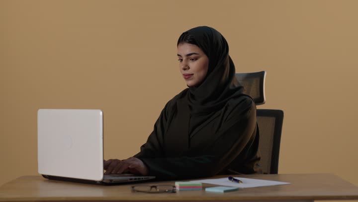 سيدة أعمال سعودية تكتب على الكمبيوتر في استوديو