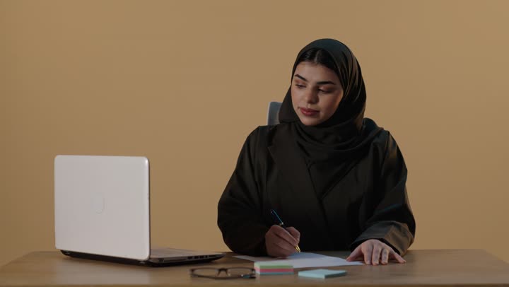 سيدة أعمال سعودية تعمل على المحمول وتكتب