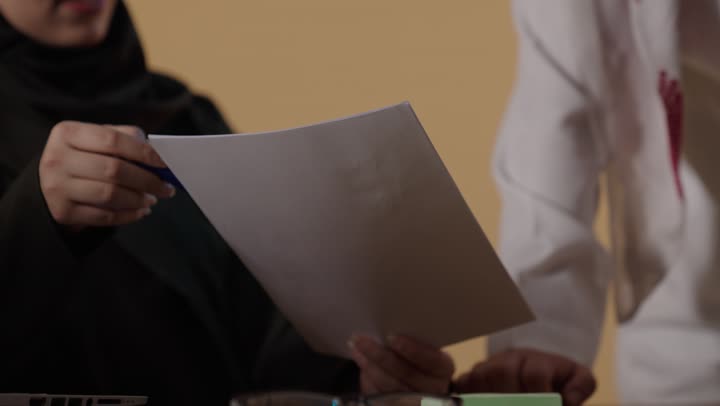 Saudi Business Colleagues Reviewing Document in Office