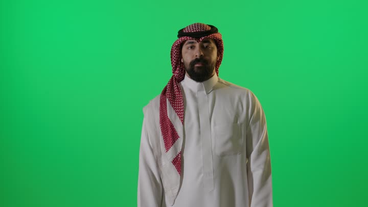 رجل سعودي يقوم بإيماءة الإبهام على خلفية خضراء