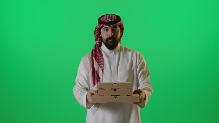رجل سعودي يحمل صناديق بيتزا كروما خضراء