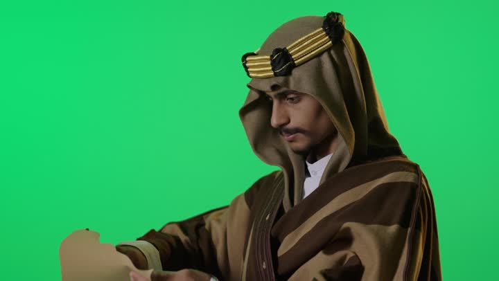 رجل سعودي بملابس يوم التأسيس يحمل وثيقة شاشة خضراء