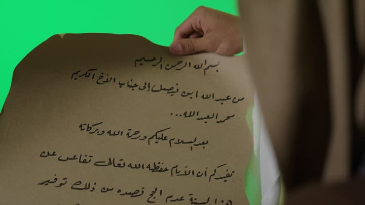 رجل سعودي يمسك وثيقة تاريخية كروما خضراء
