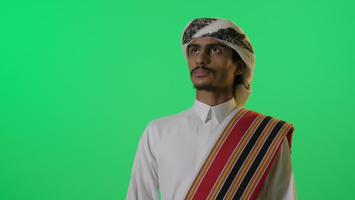 شاب سعودي بملابس يوم التأسيس التقليدية خلفية خضراء