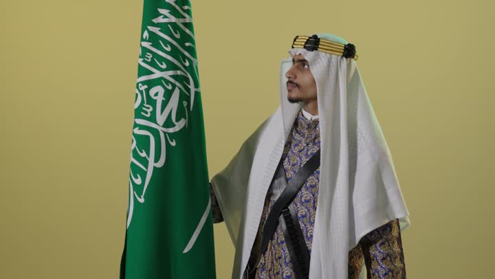 Saudi Man in Heritage Dress with National Flag