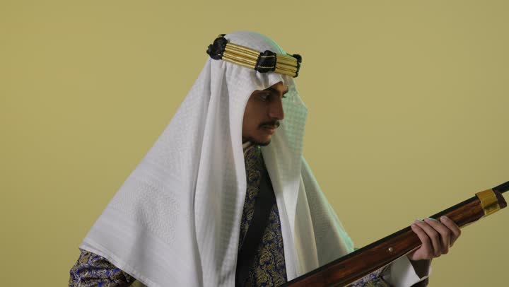 رجل سعودي بملابس يوم التأسيس مع بندقية قديمة