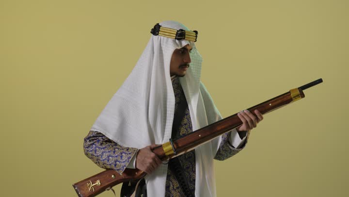 رجل سعودي بملابس يوم التأسيس التقليدية مع بندقية
