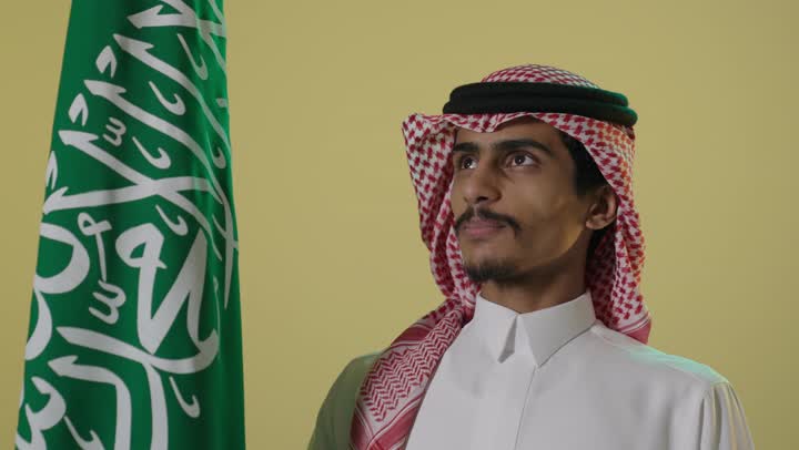 بورتريه رجل سعودي مع العلم الوطني في يوم التأسيس