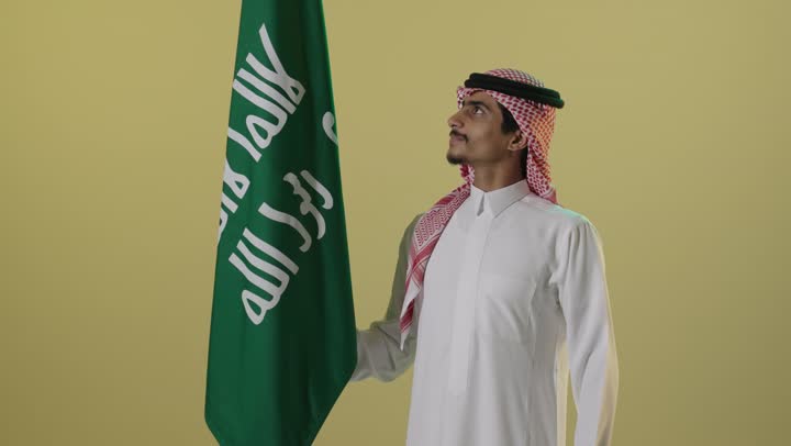 Saudi Man Standing with Flag on Founding Day Studio