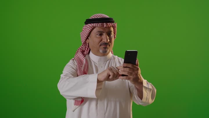 Saudi Man Using Smartphone on Green Screen Background