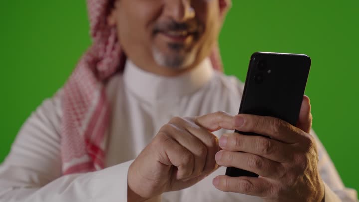 Saudi Man Using Smartphone on Green Screen