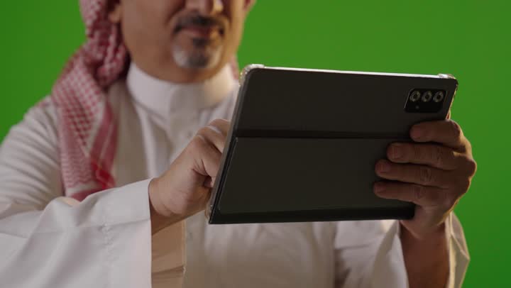 Saudi Man Using Digital Tablet on Green Screen Background