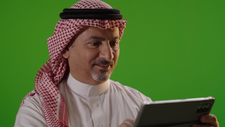 Saudi Man Using Digital Tablet on Green Screen Studio