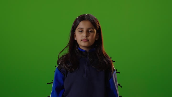 فتاه عربيه سعوديه خليجيه ترتدي الزي الكاجوال تنظر الى الكاميرا تشير بالبهام للأسفل, عدم الاعجاب , خلفية كروما خضراء,