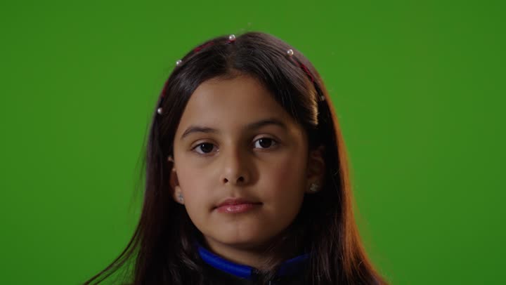 فتاه عربيه سعوديه خليجيه ترتدي الزي الكاجوال تنظر الى الكاميرا تشير بالبهام للأسفل, عدم الاعجاب , خلفية كروما خضراء,