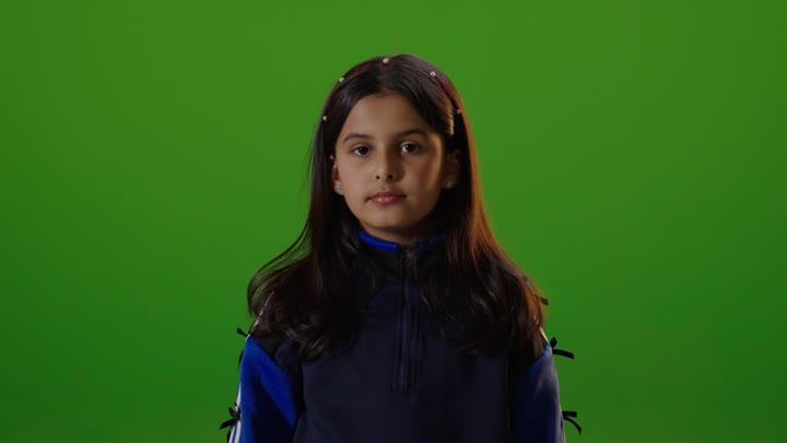 فتاه عربيه سعوديه خليجيه ترتدي الزي الكاجوال تنظر الى الكاميرا تشير باليد لطلب التوقف عن شيء ما,  خلفية كروما خضراء,