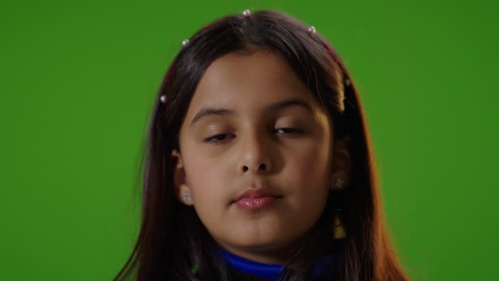 فتاه عربيه سعوديه خليجيه ترتدي الزي الكاجوال تنظر الى الكاميرا تشير باليد لطلب التوقف عن شيء ما,  خلفية كروما خضراء,