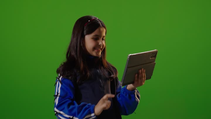 طفلة تستخدم جهاز لوحي خلفية كروما خضراء