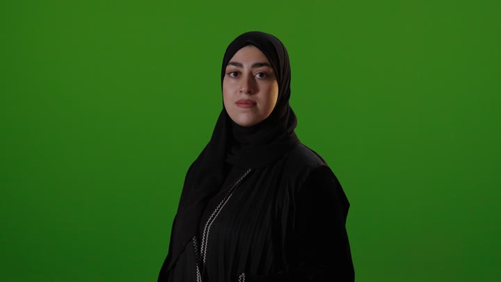 امرأة عربية مبتسمة أمام خلفية خضراء كروما فيديو استوديو