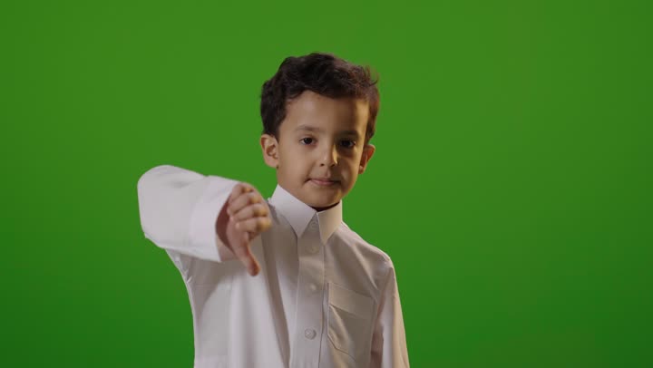 طفل سعودي يشير بعلامة عدم الإعجاب كروما خضراء