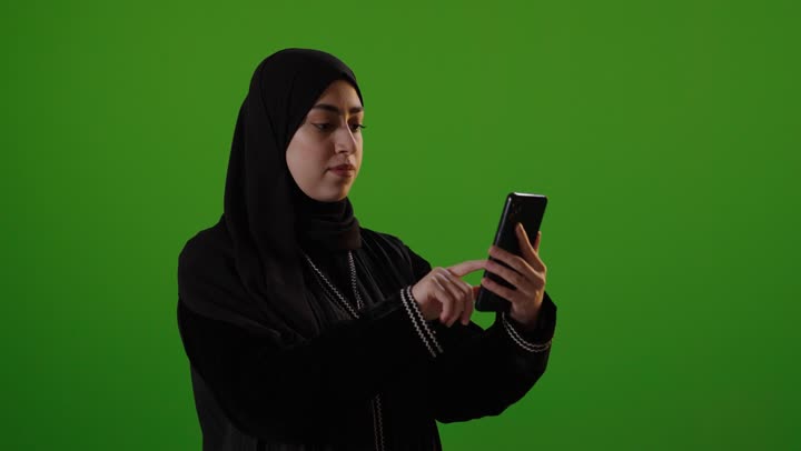 Saudi Woman Using Smartphone on Green Screen Background