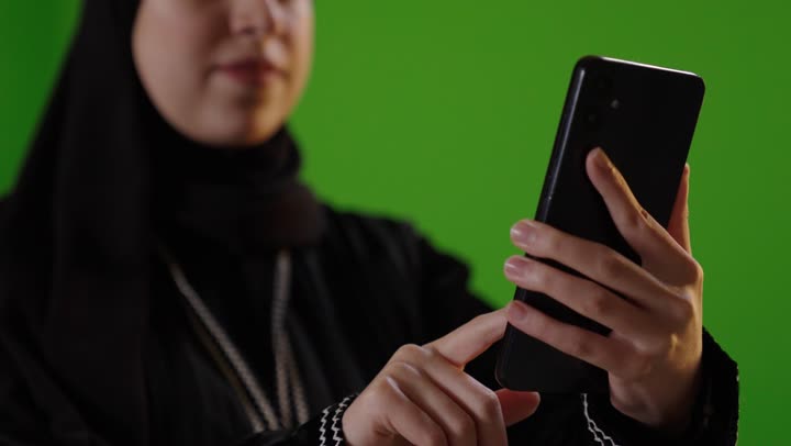 Saudi Woman Using Smartphone on Green Screen