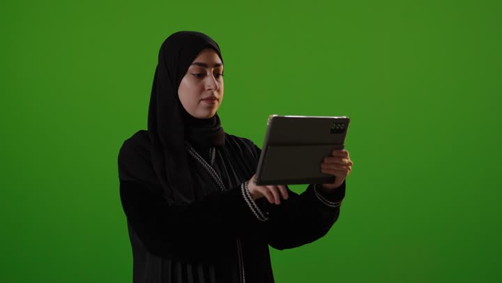 Saudi Woman Using Digital Tablet on Green Screen