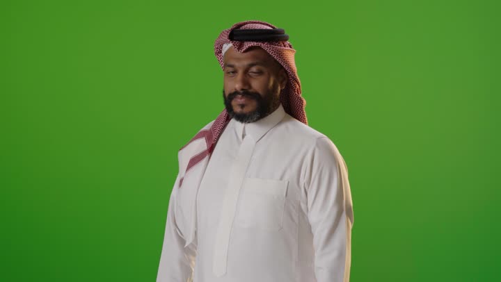 رجل سعودي بالزي التقليدي أمام شاشة خضراء