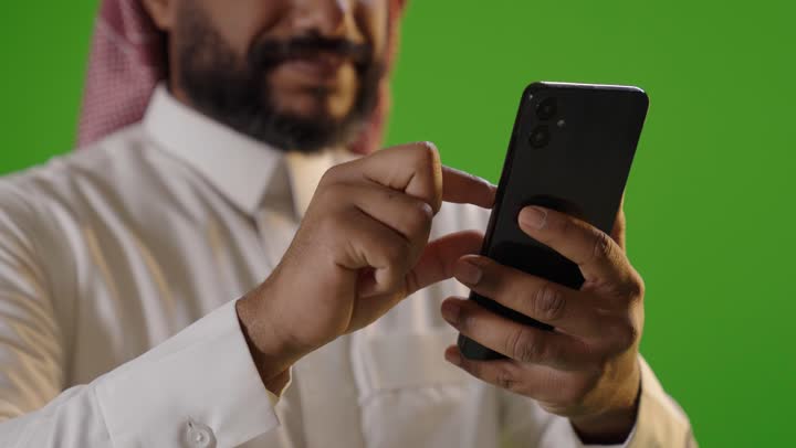 Saudi Man Using Smartphone on Green Screen Background