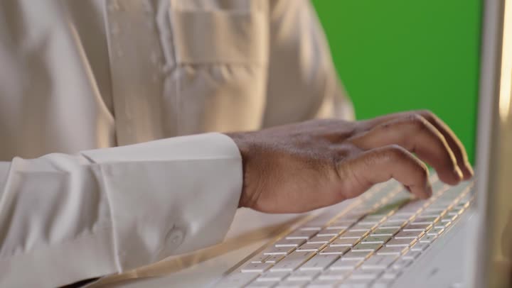 رجل عربي يكتب على لابتوب كروما خضراء