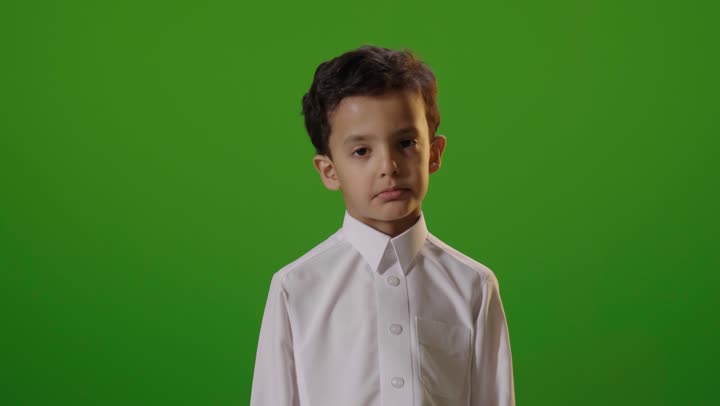 طفل سعودي بالثوب يرفع يد قف خلفية كروما خضراء