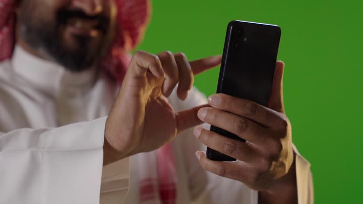 Saudi Man Using Smartphone on Green Screen Background
